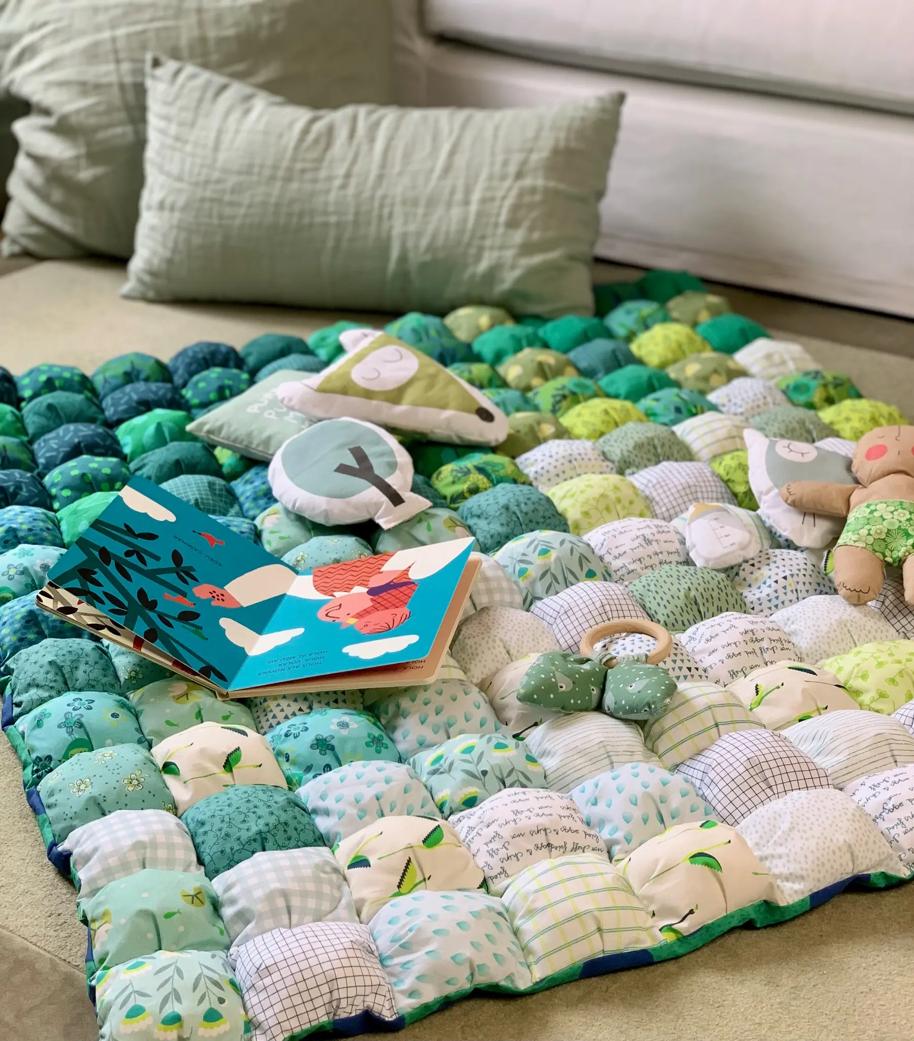 Bubble Quilt Poppy Green de La Blu usado como manta de juego para niños